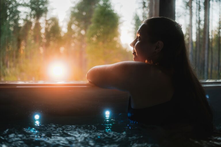 A Woman sitting in jacuzzi and admiring the midnight sun.
